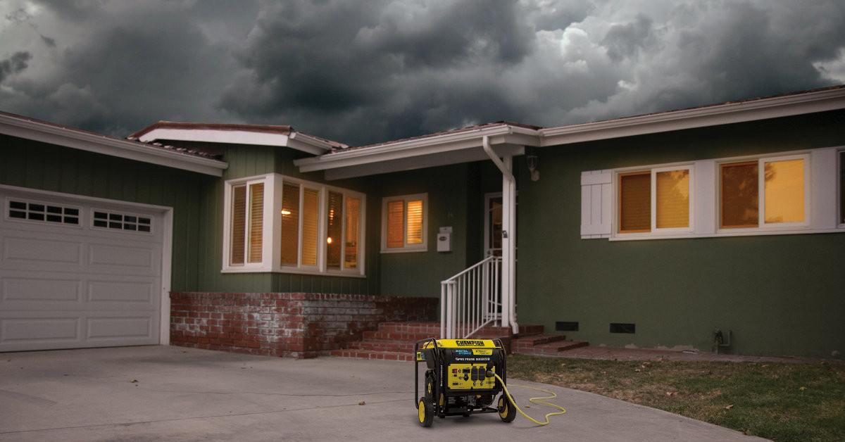 A Champion Inverter Generator on a Driveway with an extension cord to the house. A stormy sky in the background over the house, the lights are on, thanks to the generator.